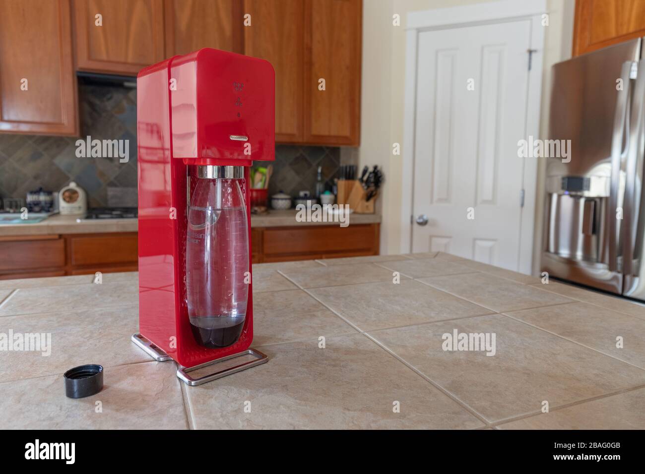 Sodastream rouge avec bouteille sur comptoir dans la cuisine Banque D'Images