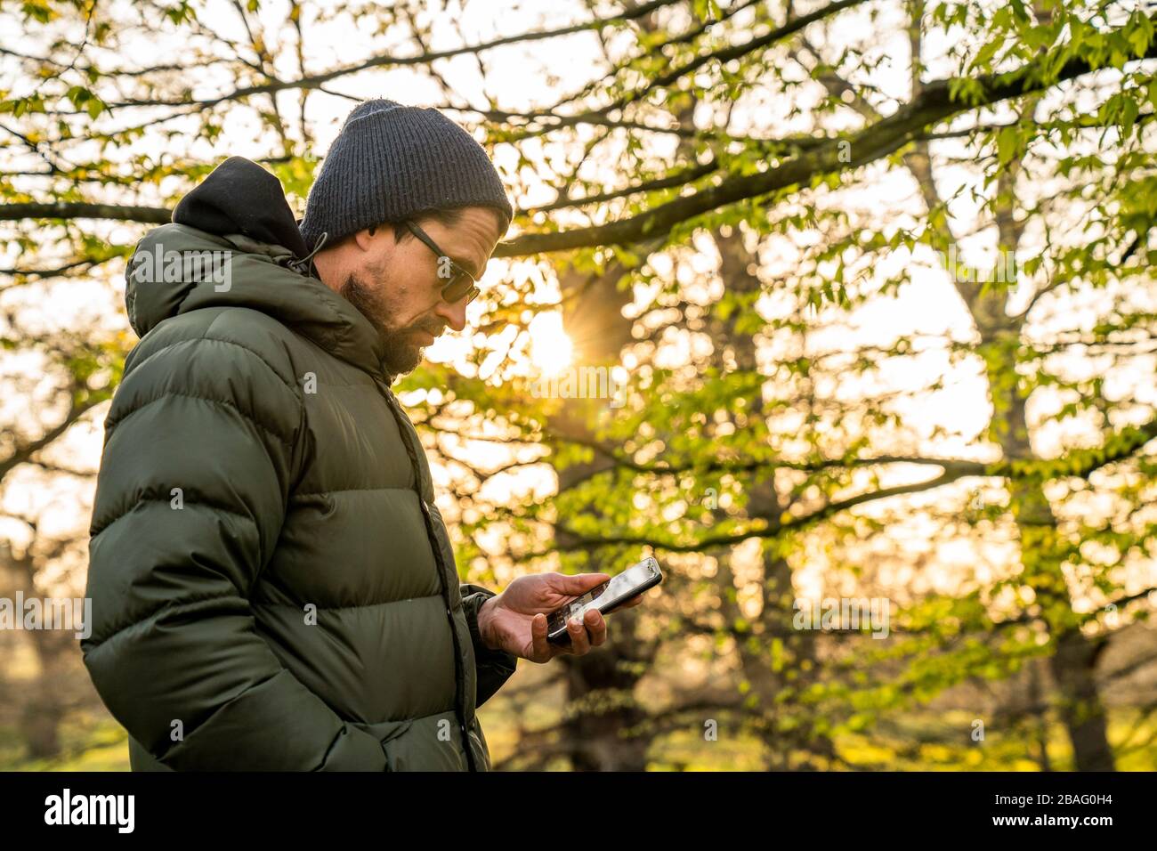 Des activités d'entraînement social à Greenwich Park. Homme du milieu des années 40 regardant le téléphone. Banque D'Images