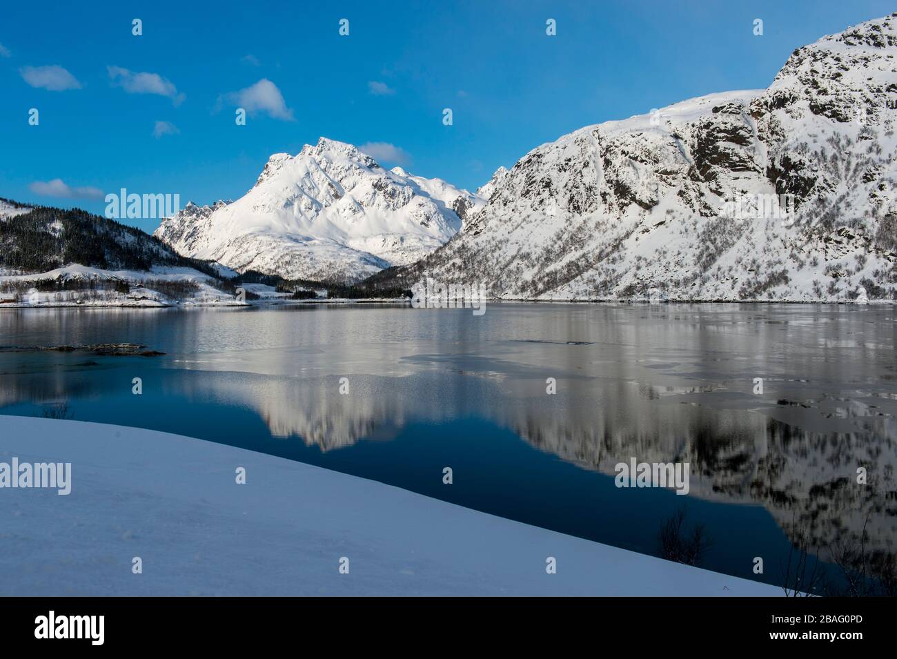 Vue sur une montagne enneigée qui se reflète dans un fjord des îles Lofoten, comté de Nordland, Norvège. Banque D'Images