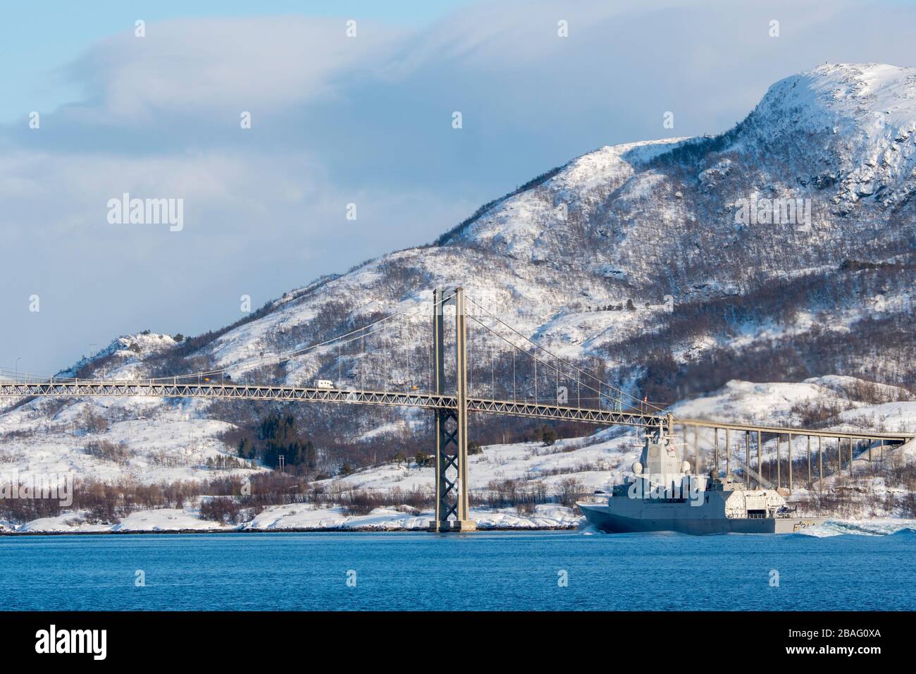 Vue sur un navire de garde-côtes norvégien dans le détroit de Tjeldsundet et le pont de Tjeldsundet près de Harstad, Norvège. Banque D'Images