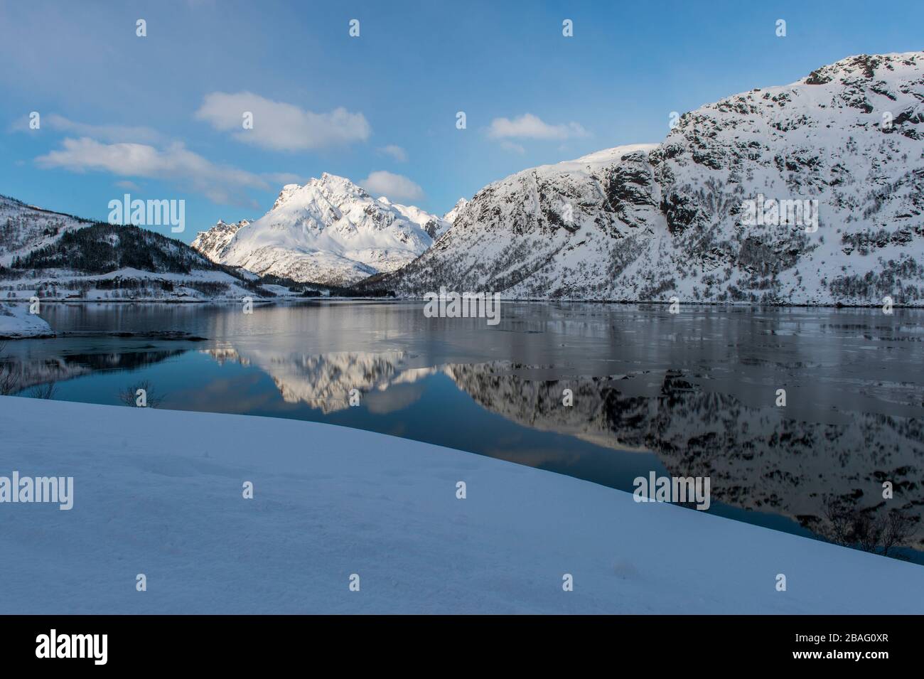 Vue sur une montagne enneigée qui se reflète dans un fjord des îles Lofoten, comté de Nordland, Norvège. Banque D'Images