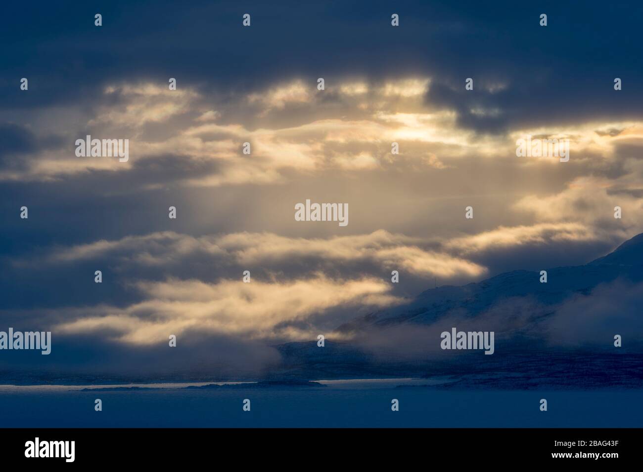 Vue depuis la zone de l'hôtel Fjallet avec une lumière spectaculaire et des nuages sur le lac Tornetrask gelé et enneigé en Laponie suédoise, dans le nord de la Suède. Banque D'Images