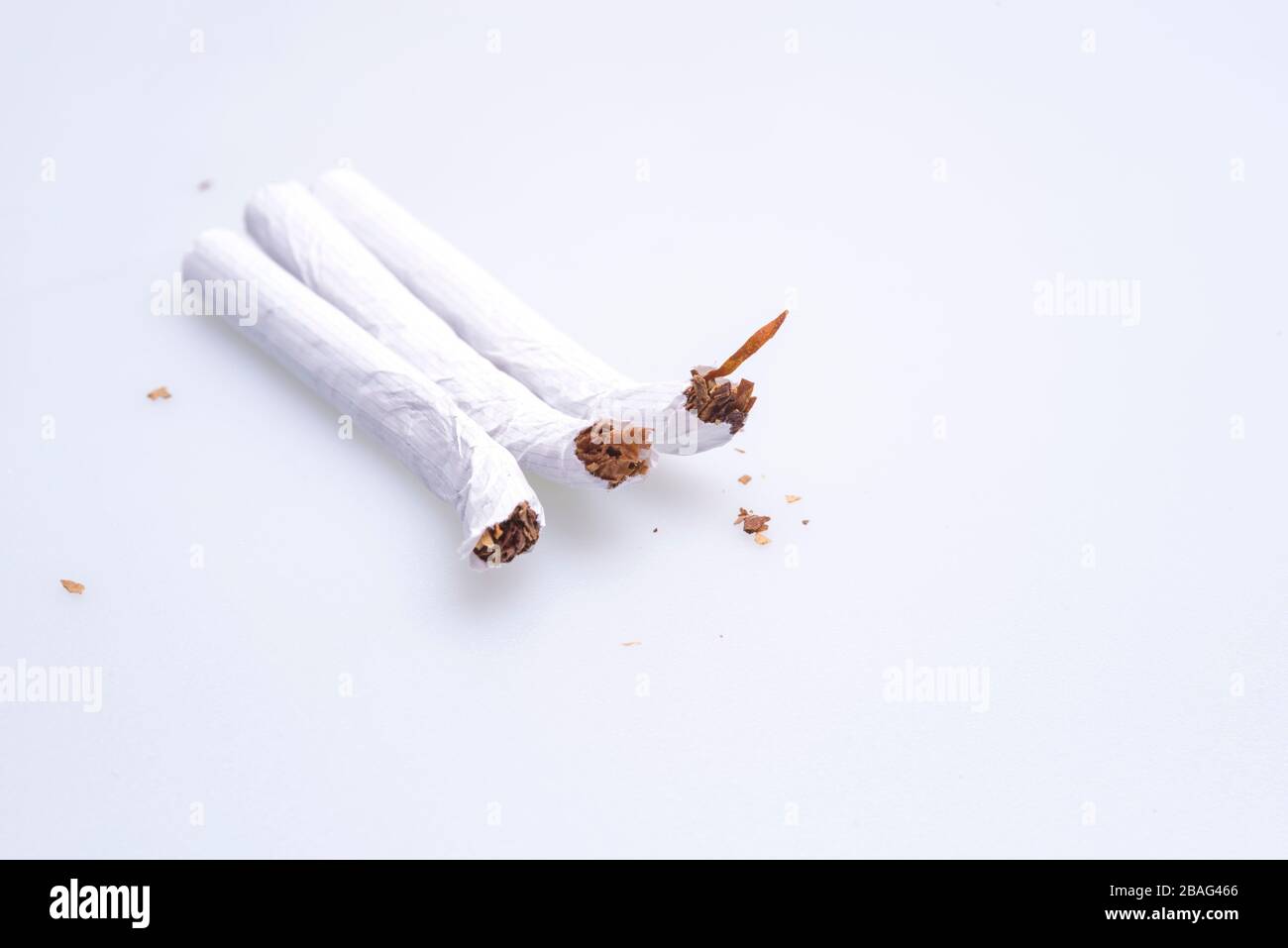 Cigarettes comprimées sur la table, sur un fond blanc Banque D'Images