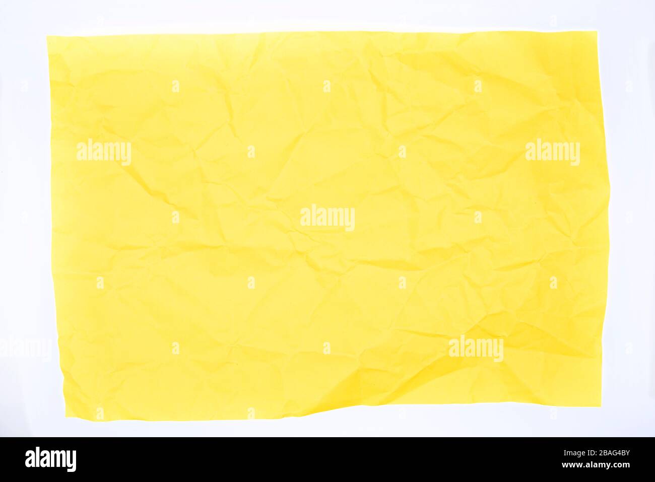 Papier froissé jaune sur fond blanc Banque D'Images
