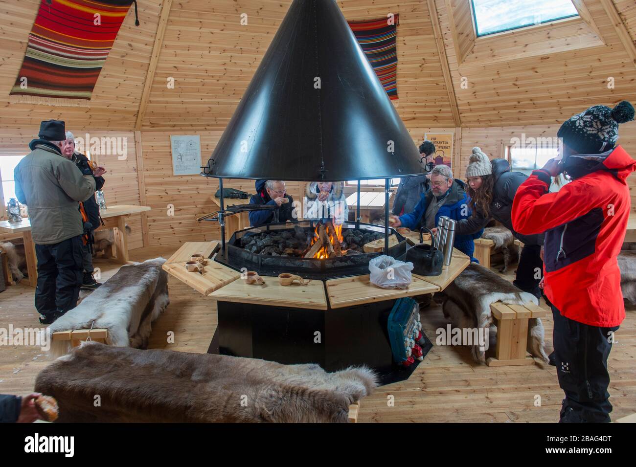 Les gens qui réchauffent une hutte dans un lieu de feu sur les pistes de ski de l'Hôtel Fjallet en Laponie suédoise, dans le nord de la Suède. Banque D'Images