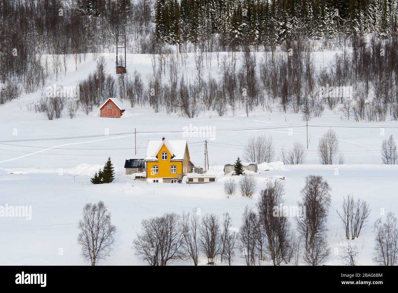 Une petite maison jaune sur la pente vallonnée du Ramfjord, un petit fjord près de la ville de Tromso dans le comté de Troms og Finnmark, Norvège. Banque D'Images