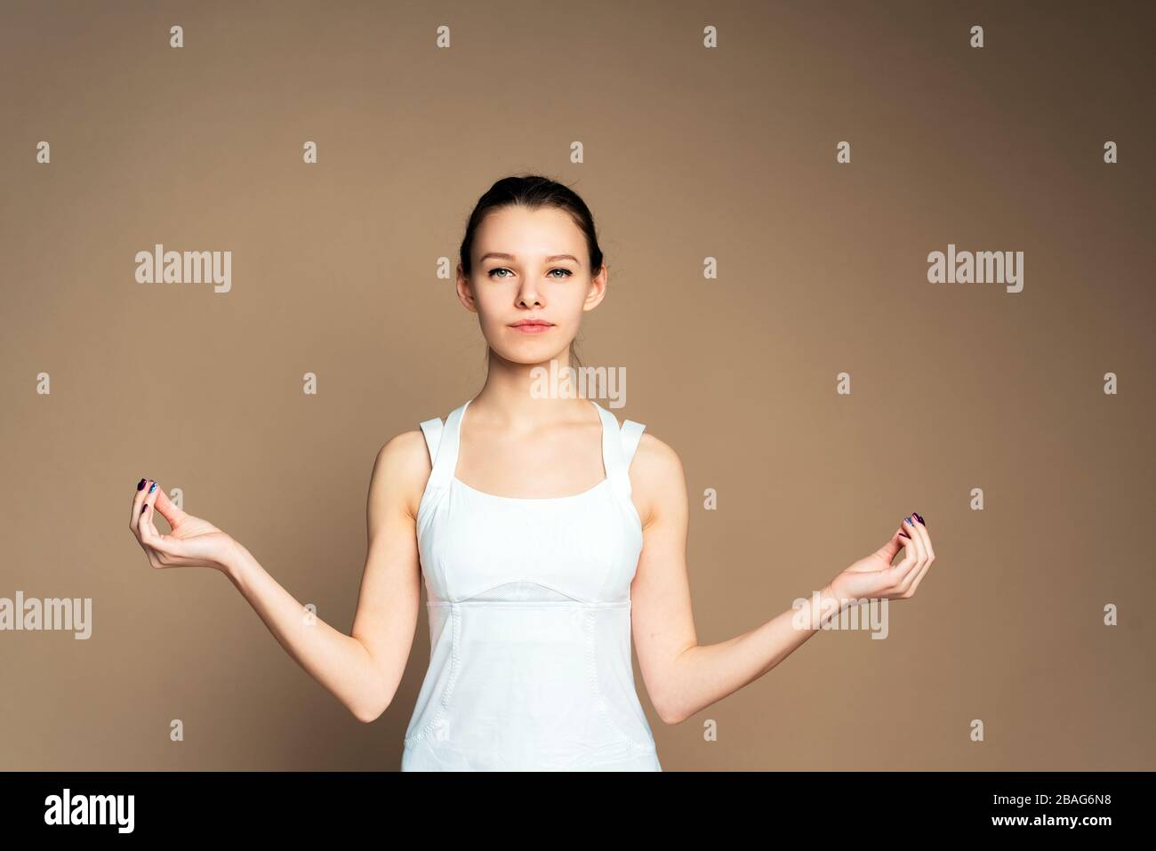 Une femme avec des cheveux dessinés en uniforme de sport fait du yoga en studio. Une fille en position lotus et médite. Isolation de la maison, rester à la maison. Banque D'Images