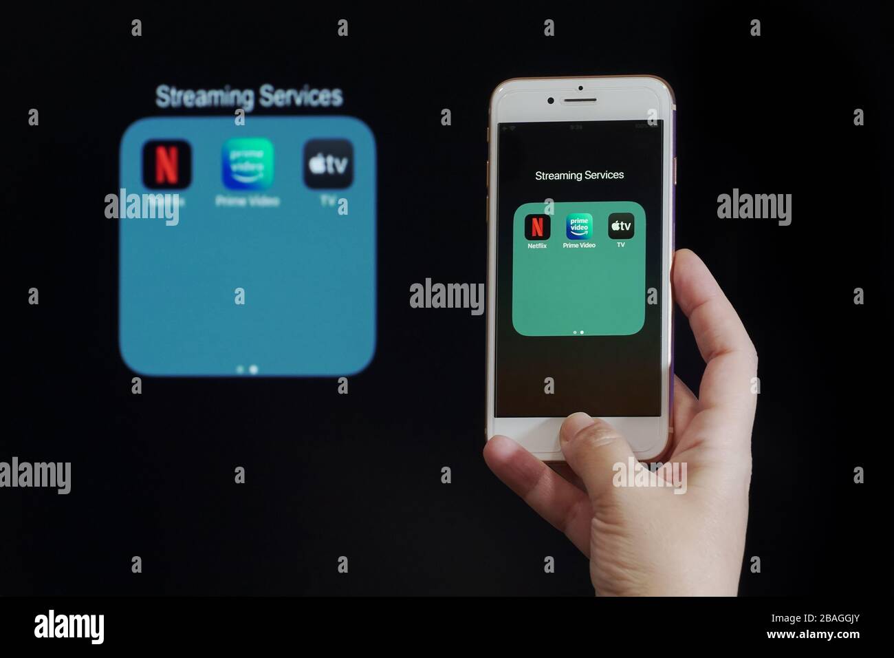 Concept de fournisseurs de contenu VSD des services de streaming. La main tient avant l'écran du téléphone mobile avec Netflix, Amazon Prime Video et Apple TV plus les logos d'apps. Banque D'Images