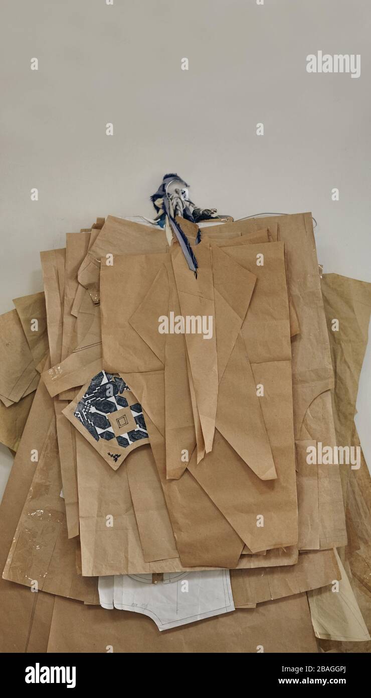 les motifs en papier pour la couture de différentes tailles pendent sur le mur dans une usine de couture intérieure. Banque D'Images