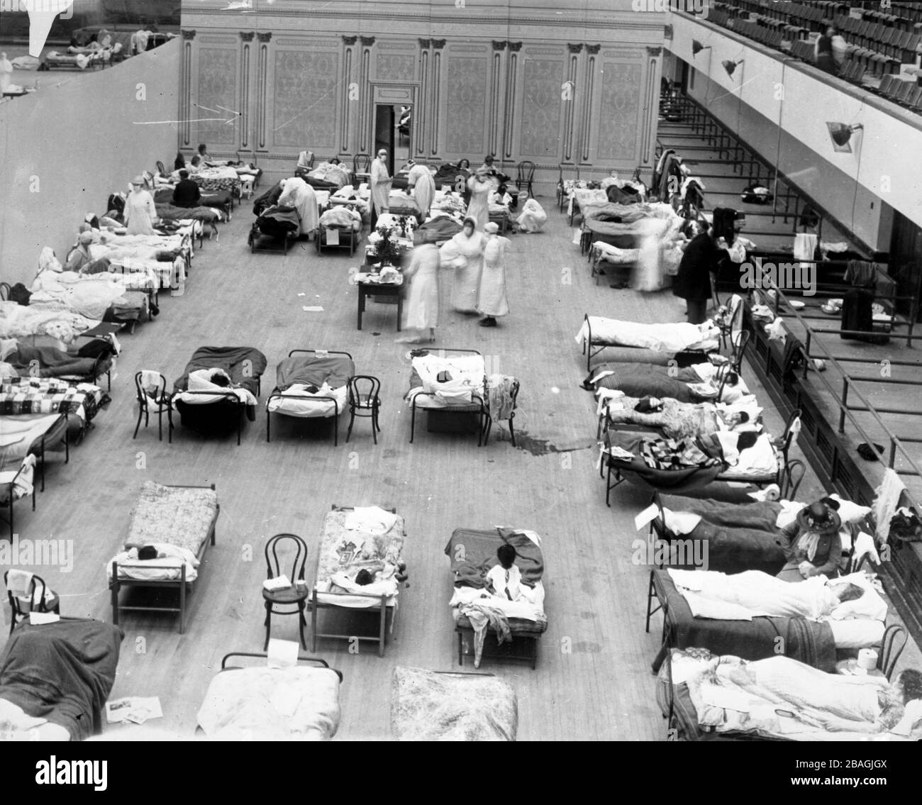 Grippe espagnole. Les infirmières de la Croix-Rouge américaine ont tendance à grippe dans des salles temporaires établies à l'auditorium municipal d'Oakland, 1918. Banque D'Images