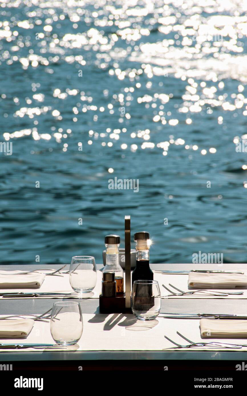 Bel endroit pour dîner au bord de la mer. Table en bordure de rive prête pour les nouveaux clients. Beaucoup d'espace-copie Banque D'Images