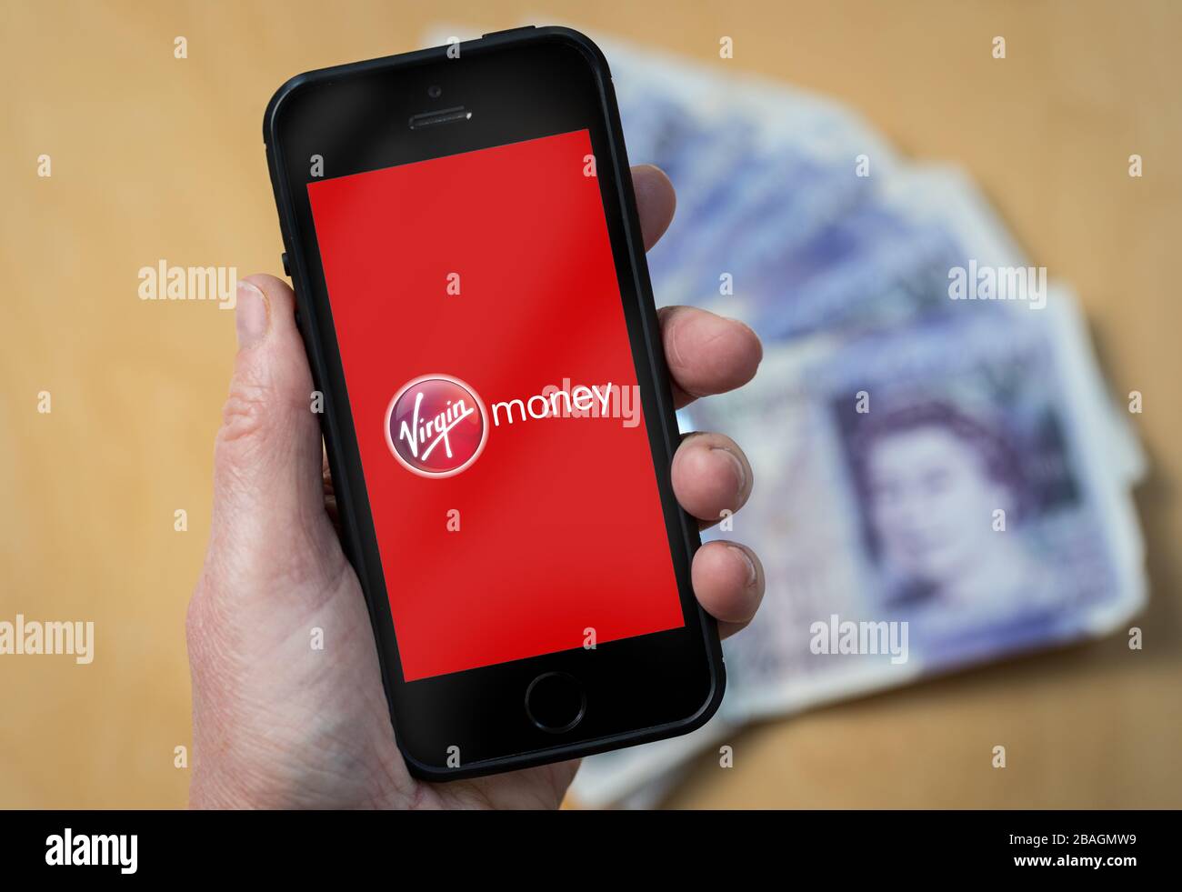 Une femme regardant le logo Virgin Money sur un téléphone mobile. (Usage éditorial uniquement) Banque D'Images