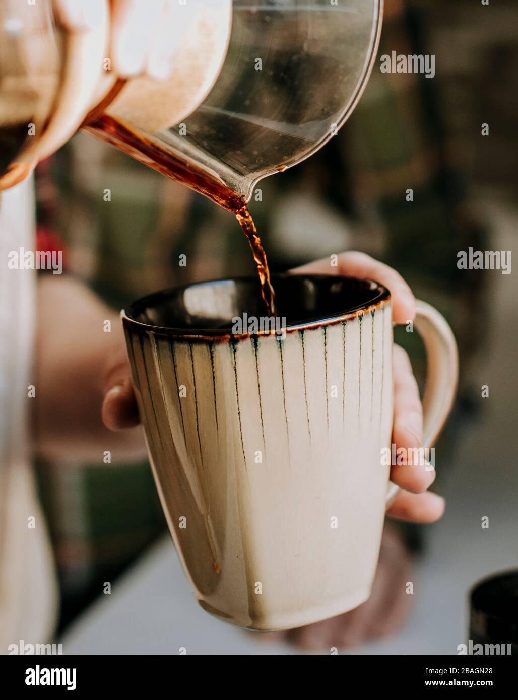 gros plan du café versé dans une tasse de café bronzé Banque D'Images