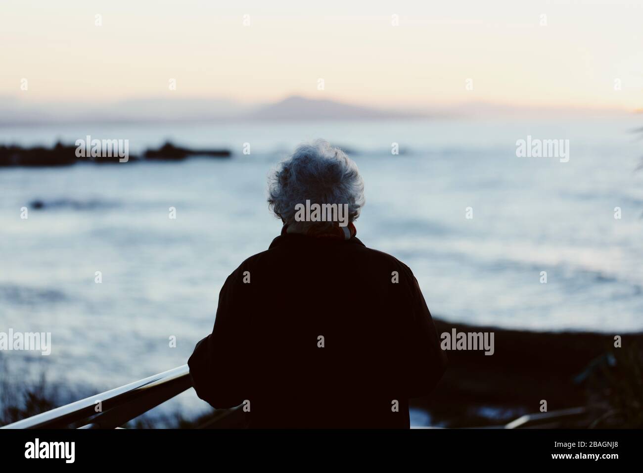 Une femme âgée qui regarde l'océan. Banque D'Images