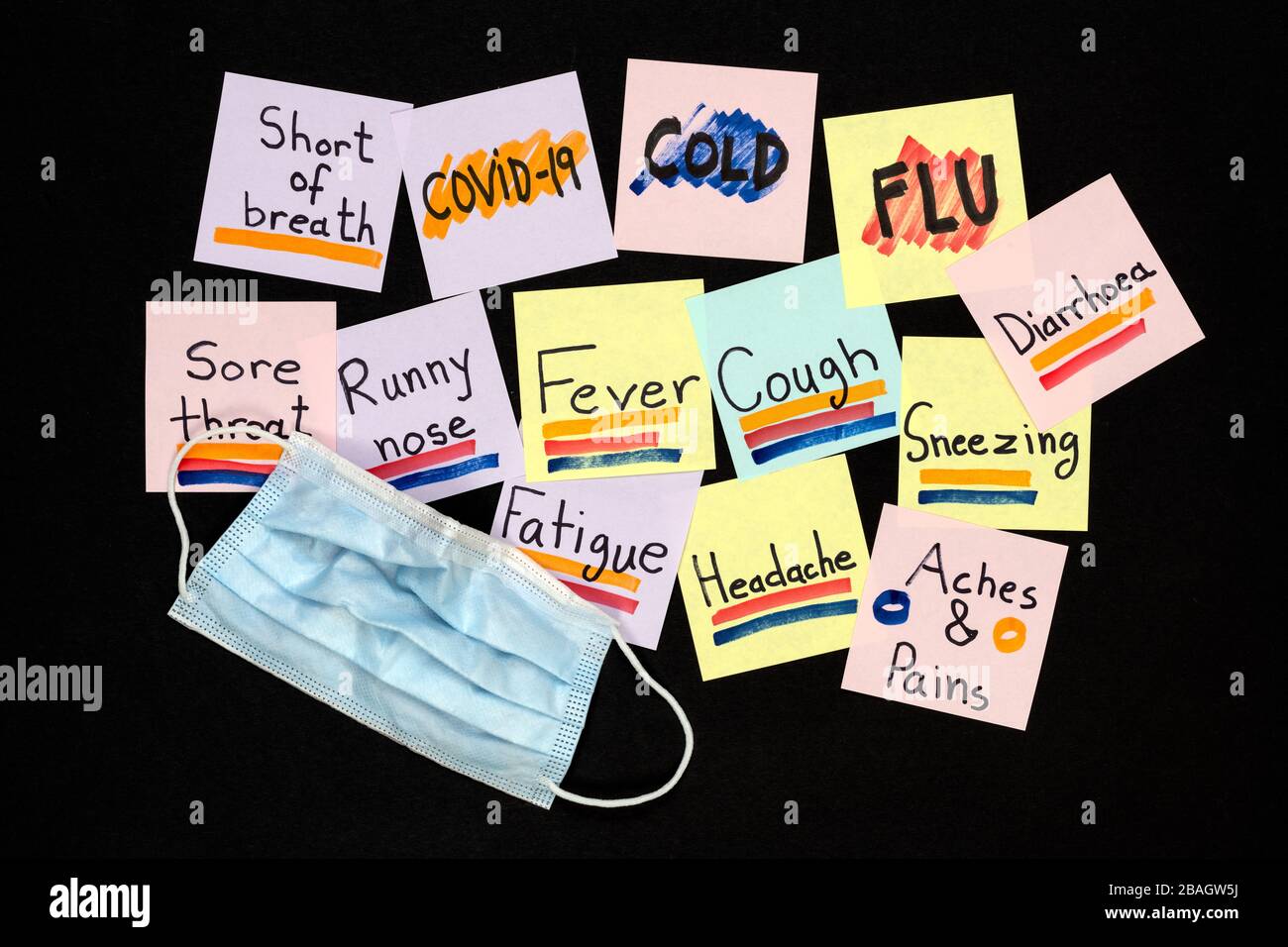 Symptômes de COVID-19, rhume et grippe communs sur des notes collantes en couleur écrites sur un fond noir. Concept de protection contre la pandémie. Banque D'Images
