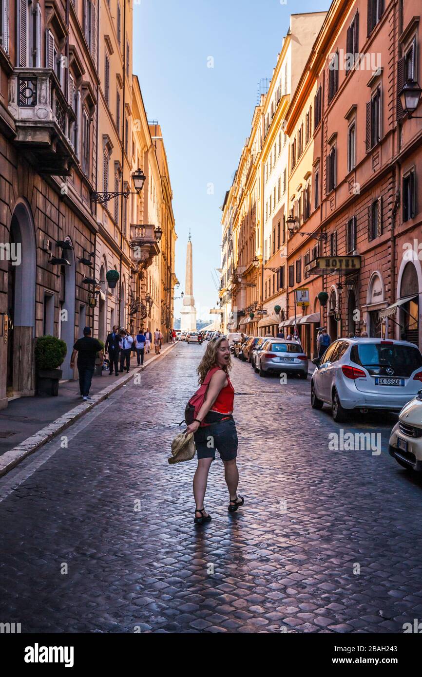 Une femme marchant dans la rue de Rome vers les marches espagnoles et Obélisque Sallustiano. Banque D'Images