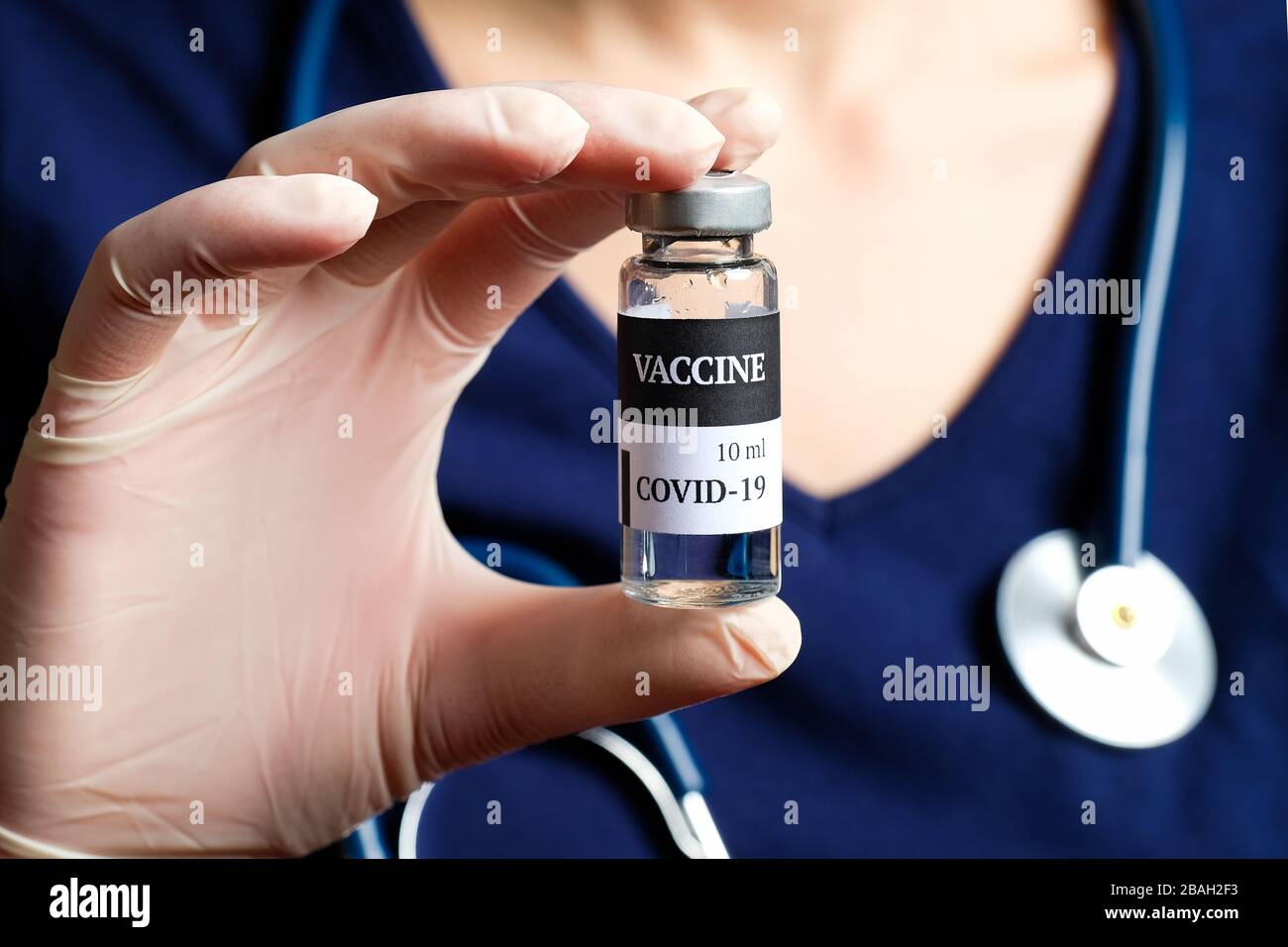 Flacon de vaccin COVID-19 de coronavirus dans les mains des infirmières. Concept de traitement du coronavirus. Banque D'Images
