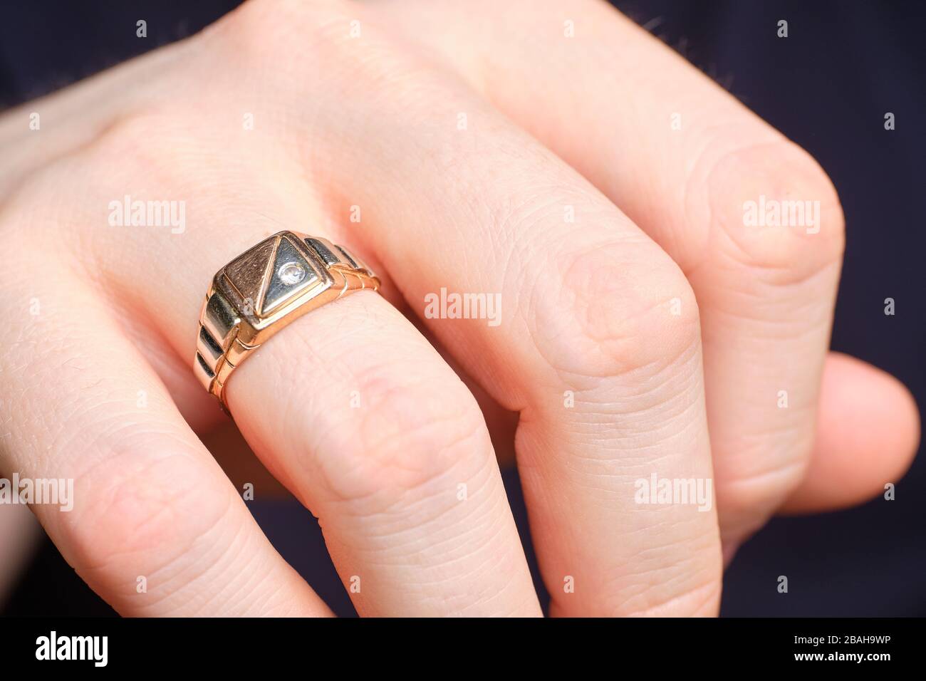 Anneau d'or sur un doigt d'homme. Gros plan. Banque D'Images