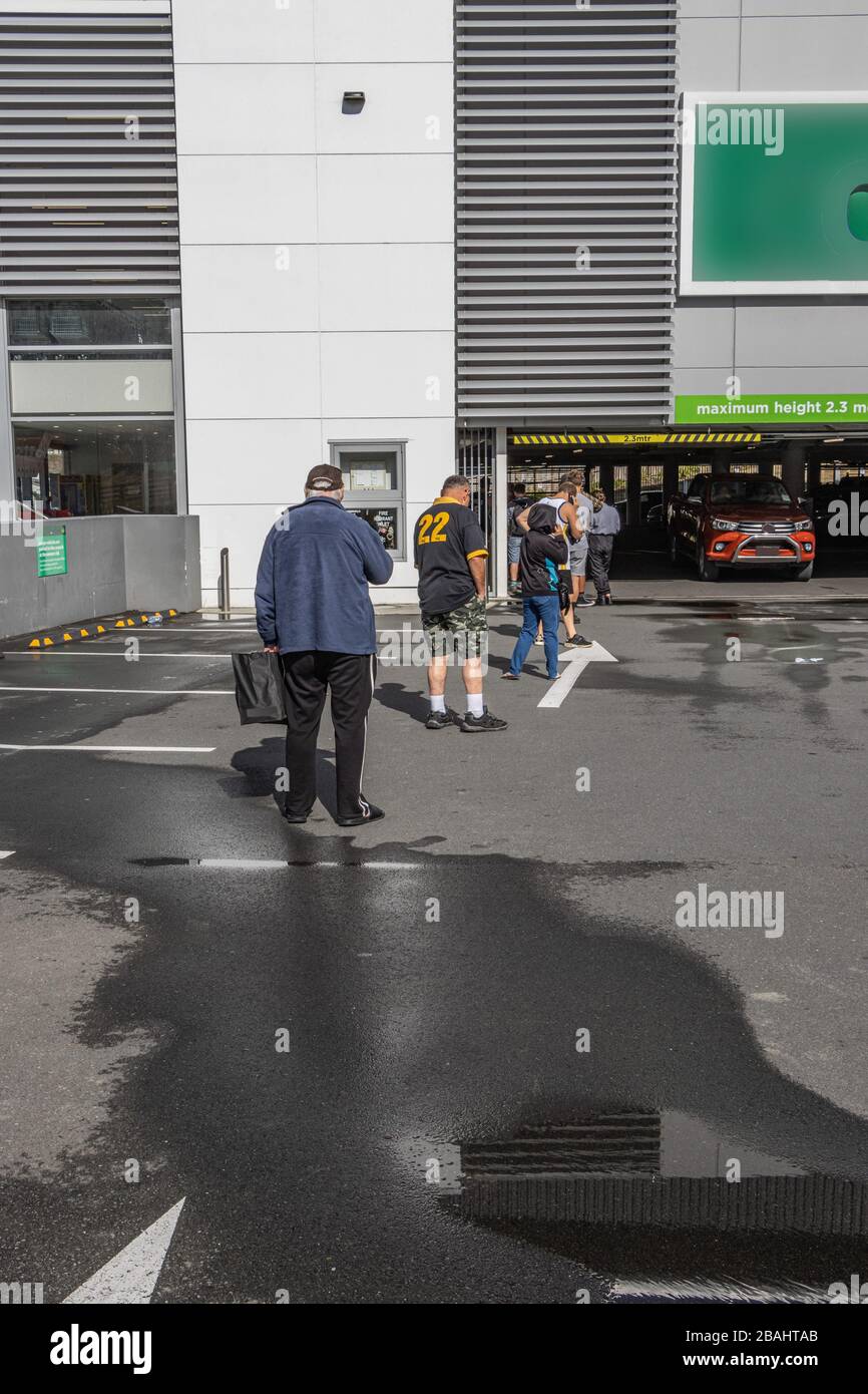 Les gens font la queue et maintiennent des distances sociales dans le parking du supermarché Banque D'Images