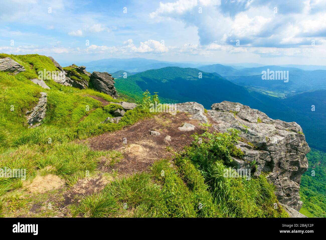 vue sur la vallée depuis le sommet d'une montagne. rochers immenses sur la colline herbacée. nuages sur le ciel. beau temps ensoleillé avec lumière aux appliques. fr Banque D'Images