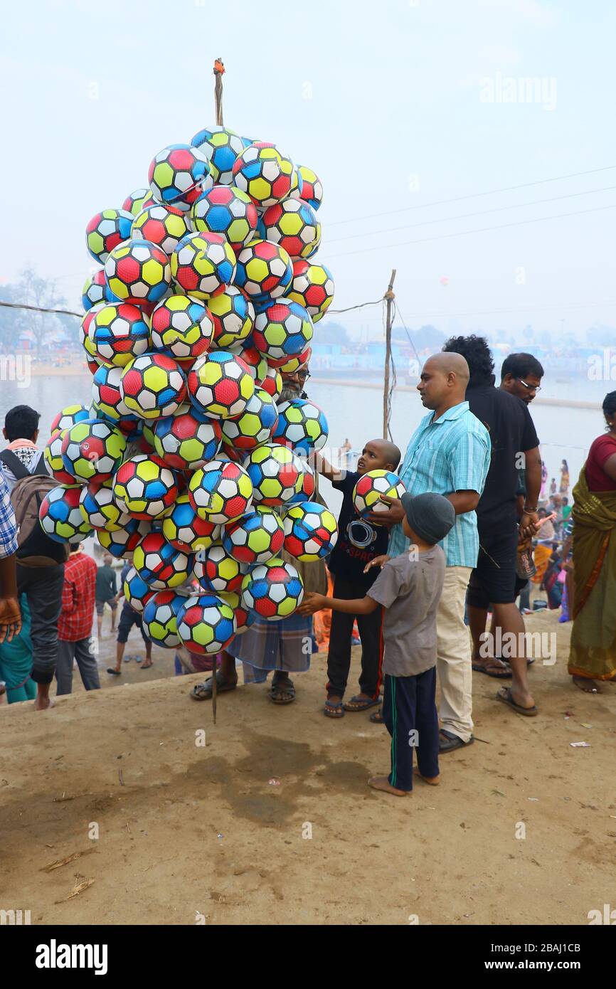 Un père achetant un ballon de football coloré pour est le soleil semble heureux. À la rivière jampanna vaagu sur medaram. Banque D'Images