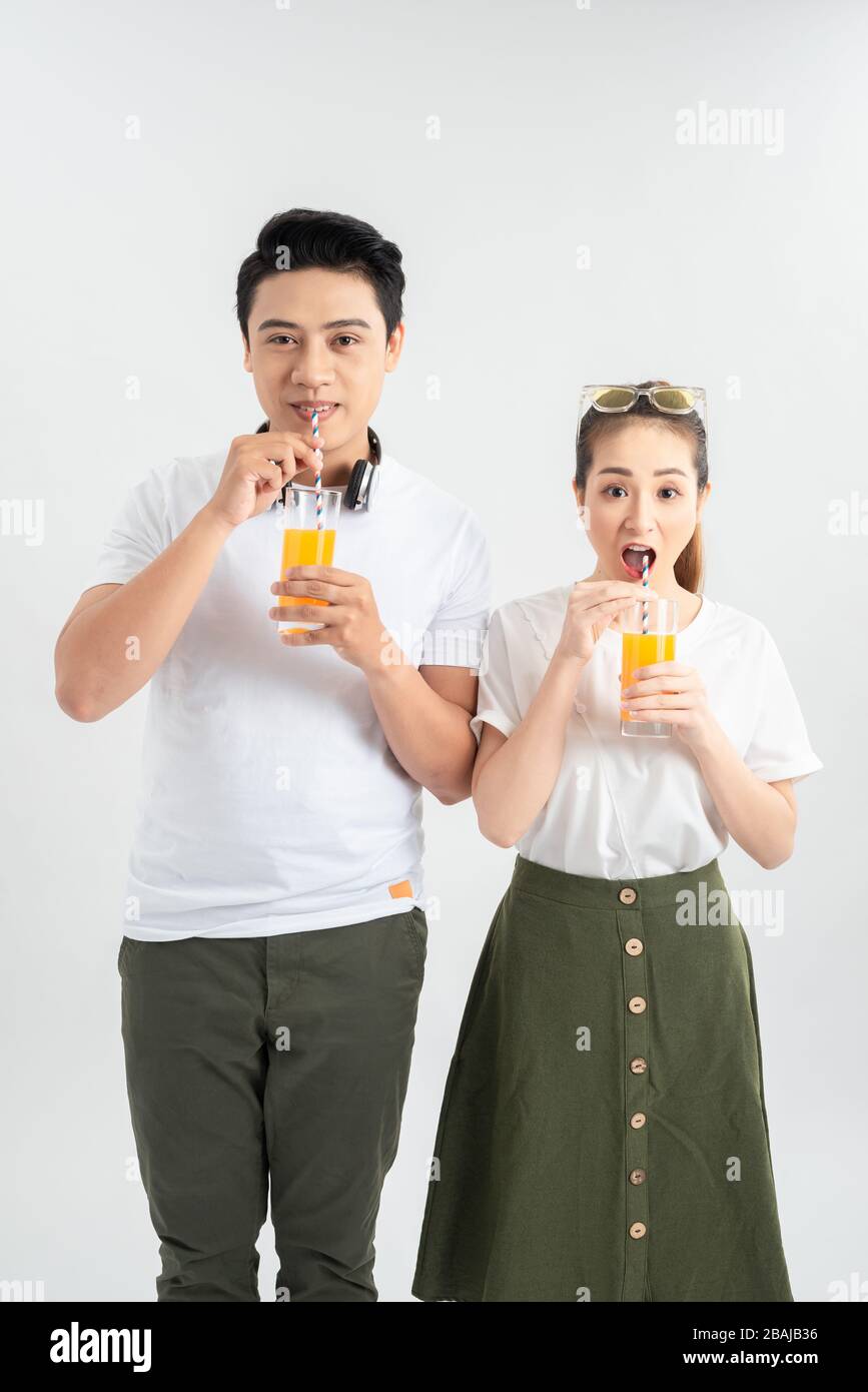 l'amour, la famille, la nourriture saine et le concept de bonheur - sourire heureux couple boire du jus sur fond blanc Banque D'Images