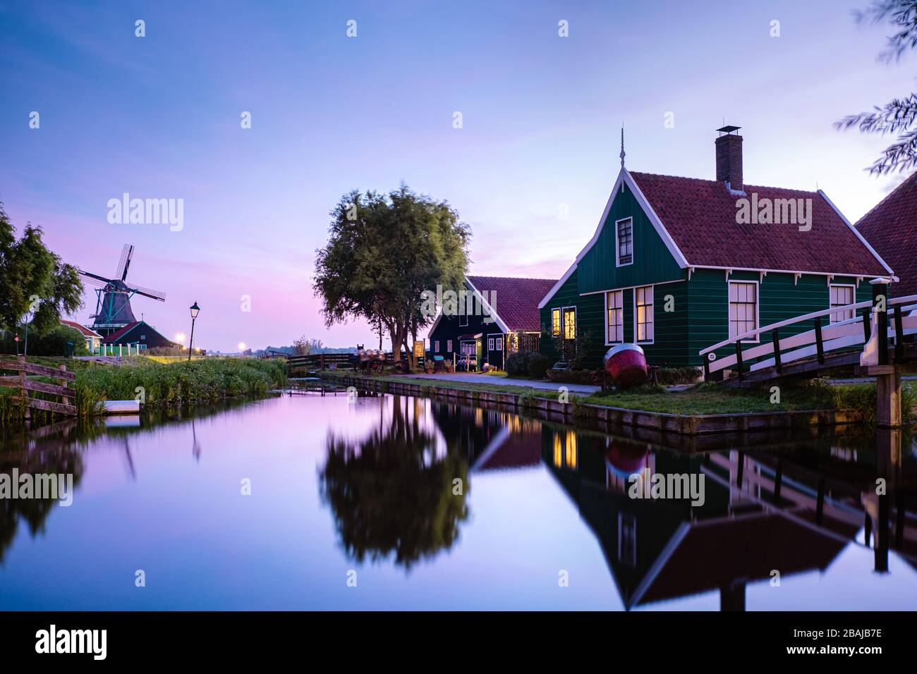 Jeunes hommes en veste de pluie jaune marchant sur une plage enneigée près du phare d'Urk Pays-Bas, hommes avec lampe à huile et manteau de ranin Banque D'Images