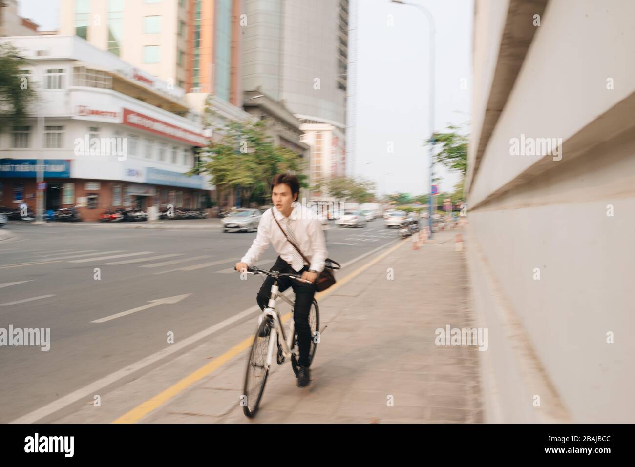 Concept de flou. Dépêchez-vous un homme d'affaires asiatique à vélo à l'heure de pointe. Jeune homme en retard pour le travail de train, réunion. La vie professionnelle et la concurrence commerciale. Banque D'Images