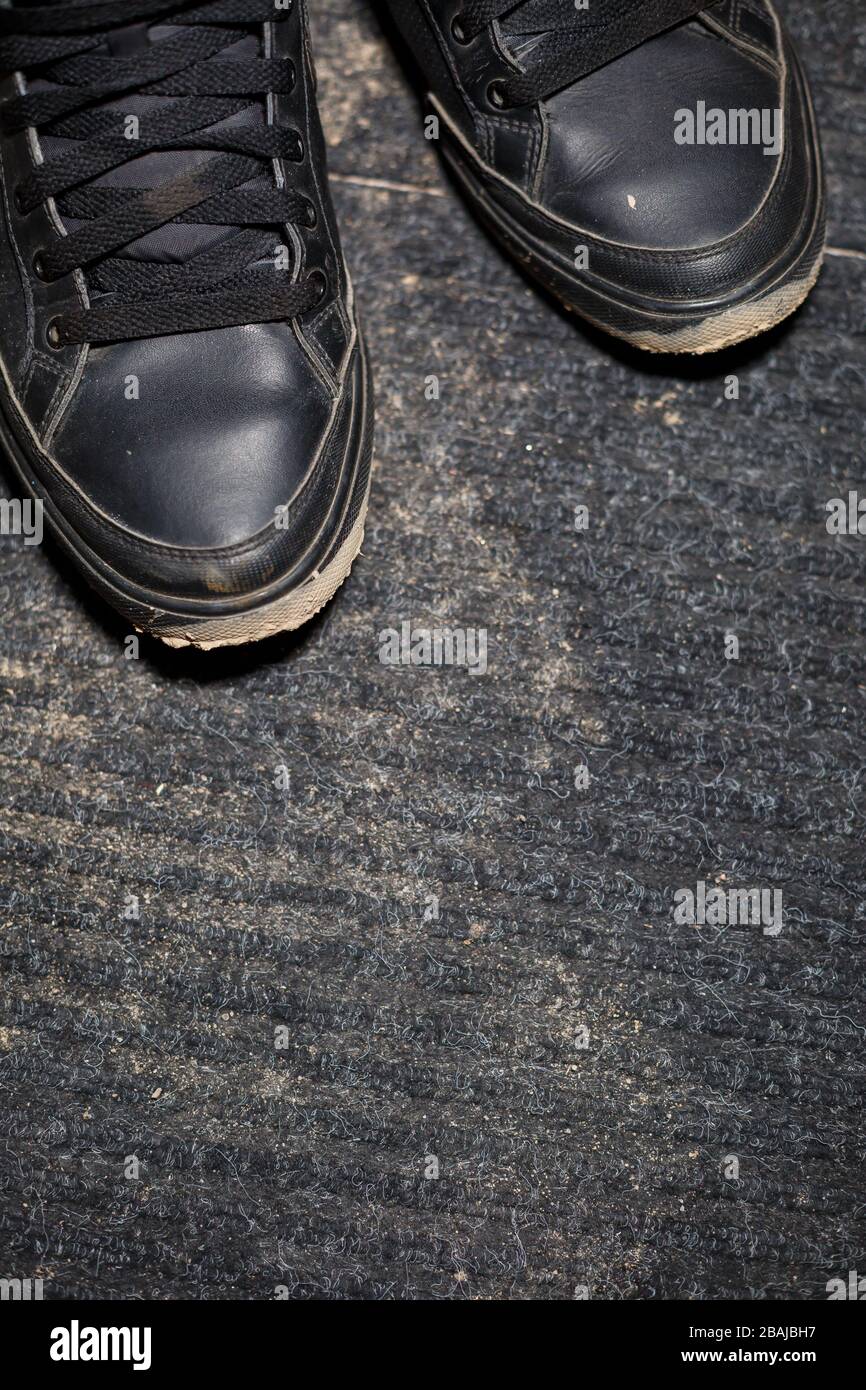 chaussures sales sur un tapis noir avec un marais dispersé Photo Stock -  Alamy
