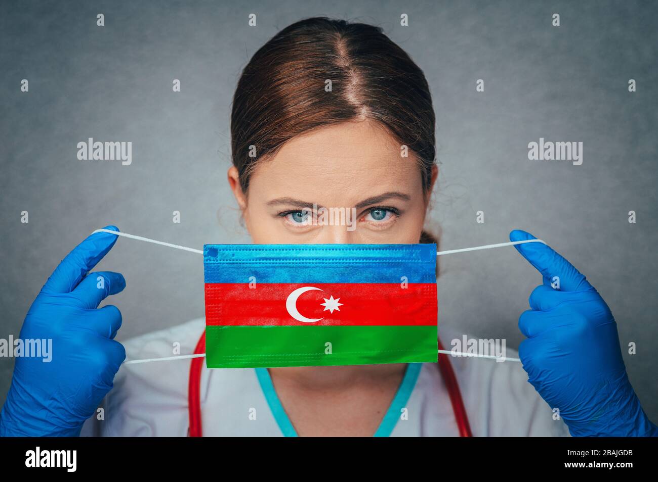 Coronavirus en Azerbaïdjan médecin femelle Portrait tenir protéger le masque médical chirurgical visage avec drapeau national de l'Azerbaïdjan. Maladie, virus Covid-19 à Aze Banque D'Images
