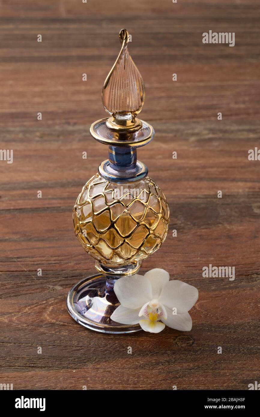 Bouteille de parfum arabe vintage faite à la main avec une fleur d'orchidée blanche Banque D'Images