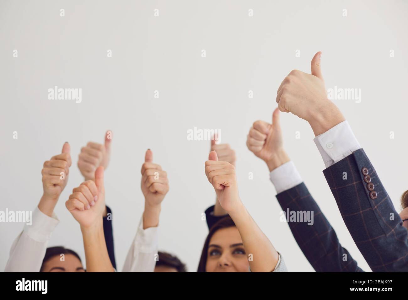 Pouce vers le haut. Le groupe de personnes tient les félicitations pouce vers le haut sur un fond blanc. Banque D'Images