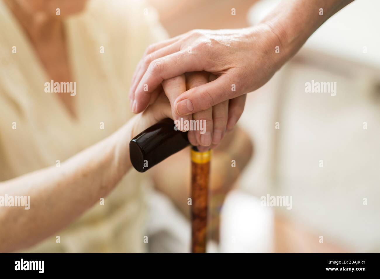Infirmière consolant sa patiente âgée en la tenant les mains Banque D'Images