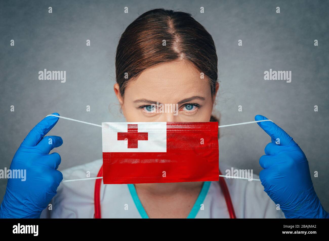 Coronavirus aux Tonga Doctor féminin Portrait tenir protéger le masque médical chirurgical du visage avec le drapeau national des Tonga. Maladie, virus Covid-19 à Tonga, conceps Banque D'Images