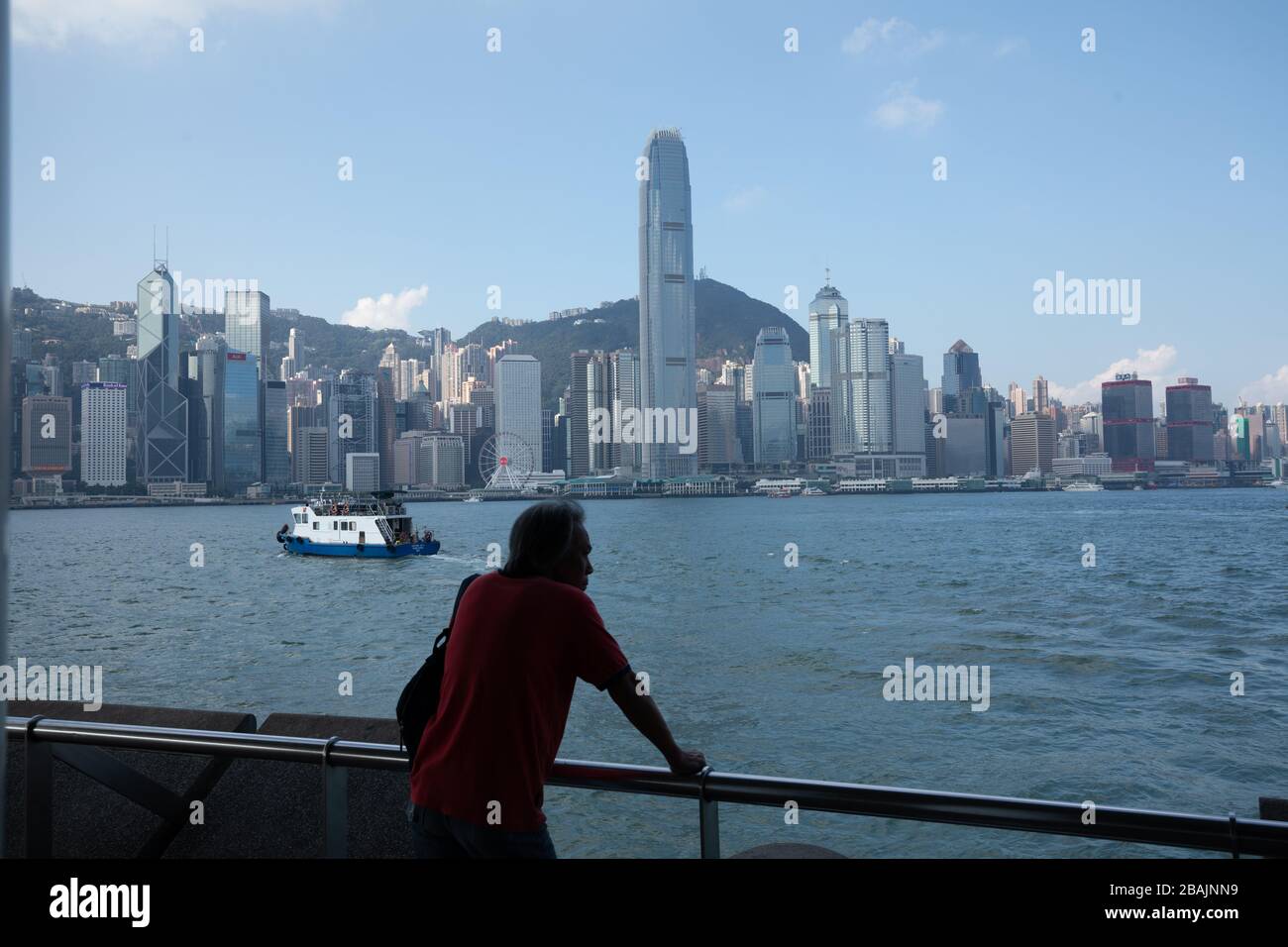 Une personne qui regarde le port avec vue sur la Tour 2 de la SFI, Centre financier international Hong Kong Central en arrière-plan Banque D'Images