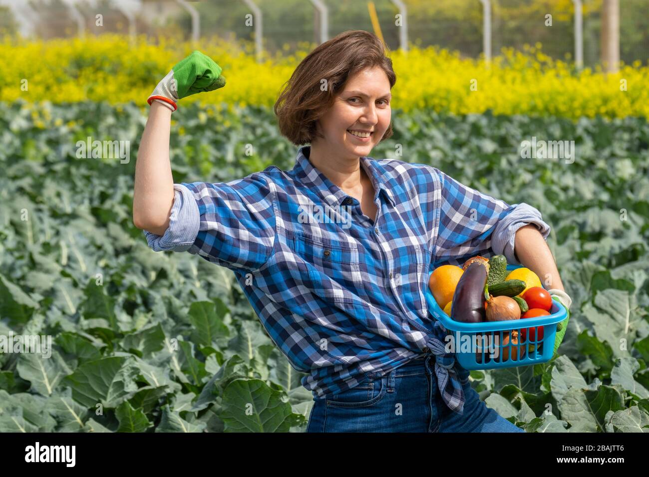 la femme montre joyeusement combien d'énergie elle doit travailler dans le secteur agricole. la femme qui travaille dans un domaine agricole par beau temps. portrait d'une jeune et dure femme qui travaille sur le terrain. une femme est fatiguée et se repose Banque D'Images