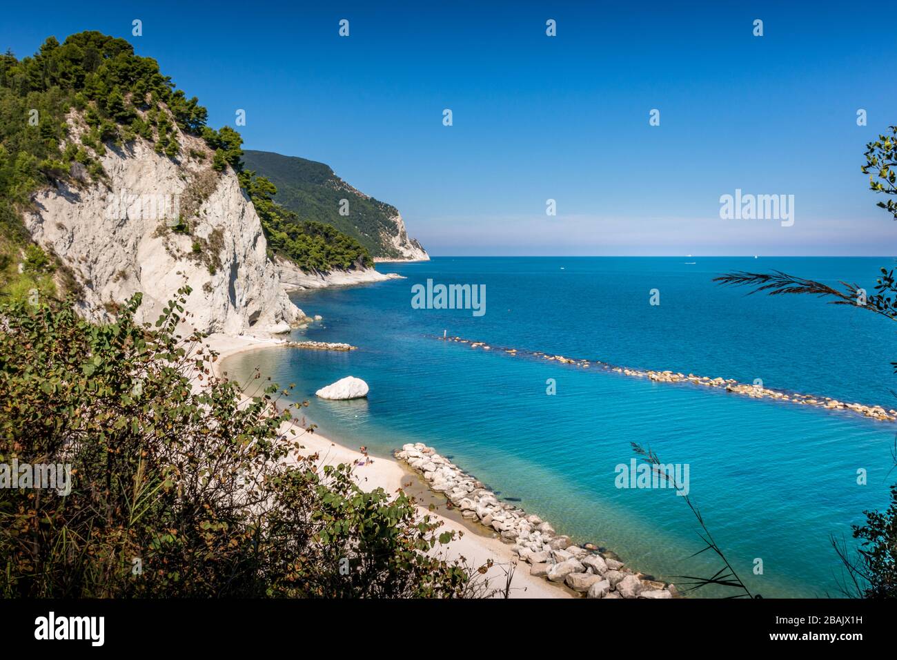 Plage de Numana Alta, sur la Riviera italienne avec les falaises blanches et l'eau bleu clair de l'adriatique lors d'une journée d'été bleu clair Banque D'Images