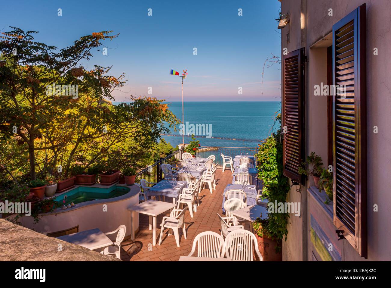 Un restaurant ensoleillé terrasse extérieure donnant sur la mer Adriatique sur la Riviera italienne, Numana, Marche, Italie Banque D'Images