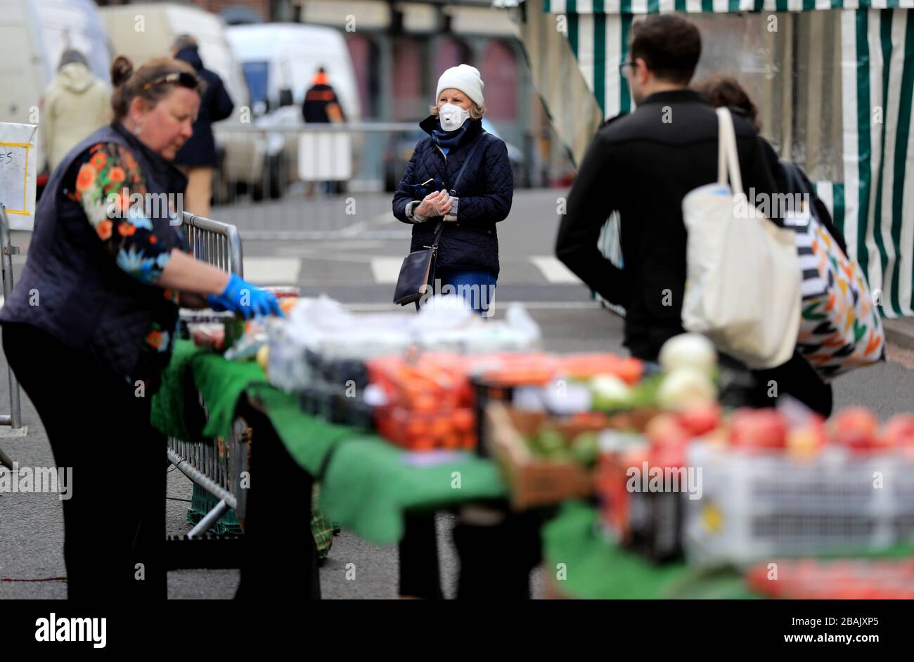 Un membre du public porte un masque protecteur tout en faisant du shopping sur un marché de Grantham, dans le Lincolnshire, alors que le Royaume-Uni continue de se verrouiller pour aider à freiner la propagation du coronavirus. Banque D'Images