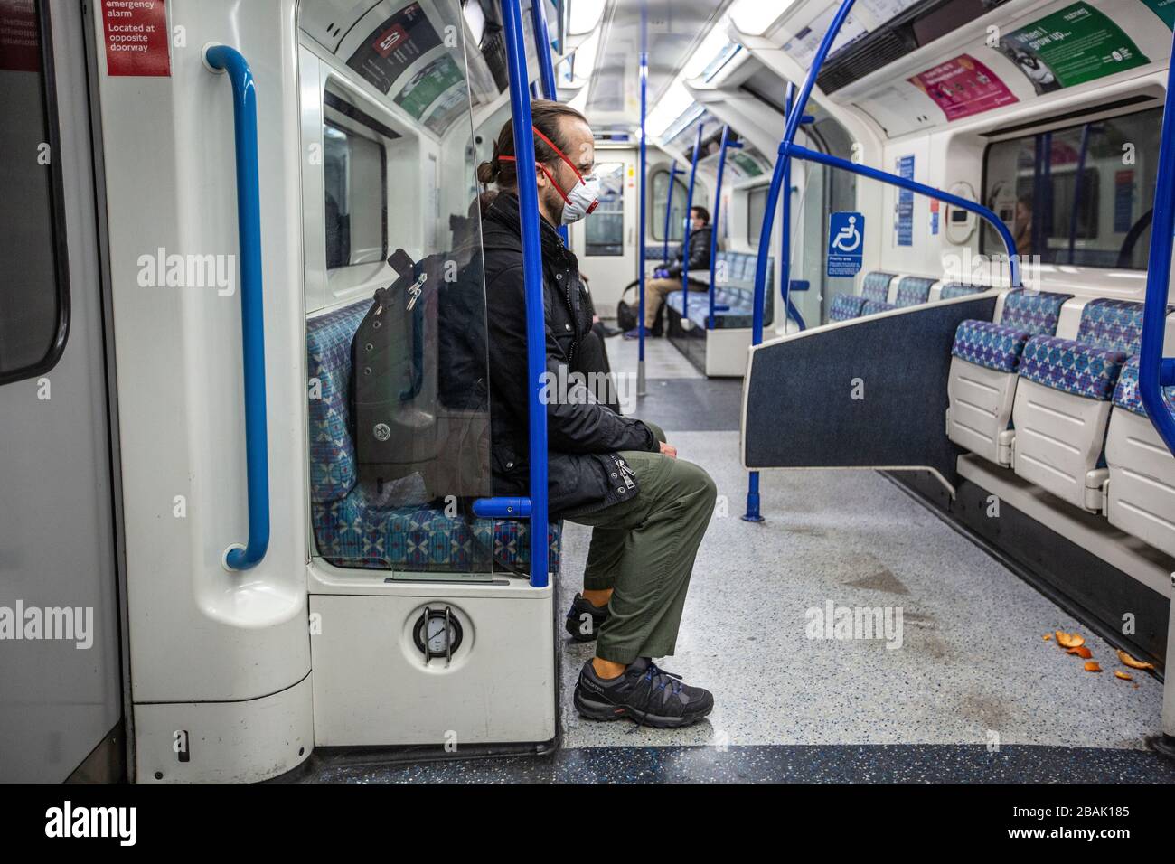 Un homme portant un masque respiratoire dans le métro de Londres, les navetteurs étant parmi les plus exposés à la propagation de l'infection par le coronavirus Banque D'Images