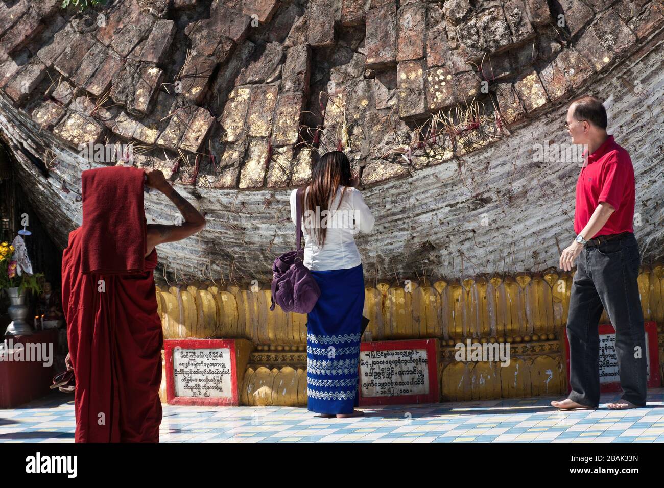 Un moine bouddhiste et une femme dévot priant à l'ancienne HTI de la Pagode Shwemawdaw, Bago, Myanmar Banque D'Images