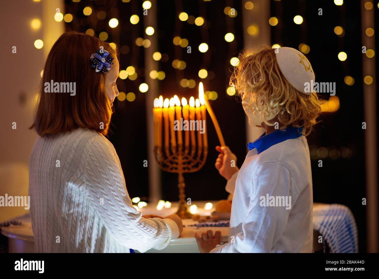 Les enfants célèbrent Hanoukkah. Fête juive des lumières. Les enfants éclairent les bougies sur