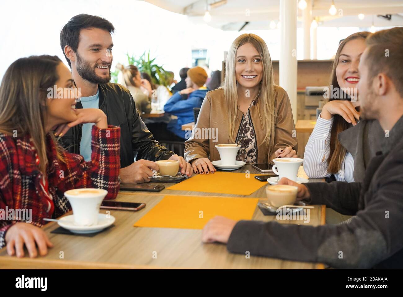 Groupe de personnes buvant du cappuccino dans un bar - les amis accrochés les uns avec les autres et parlant - Smerie garçons ang filles ayant des conversations assis arou Banque D'Images