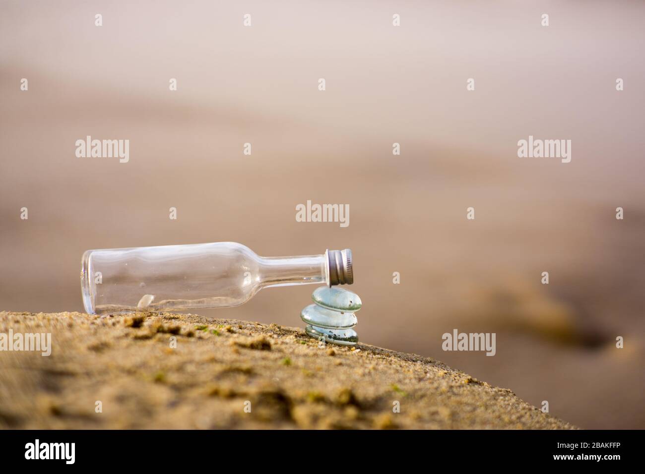 Bouteille transparente sur pile de pierres en verre symbolisant l'équilibre Banque D'Images