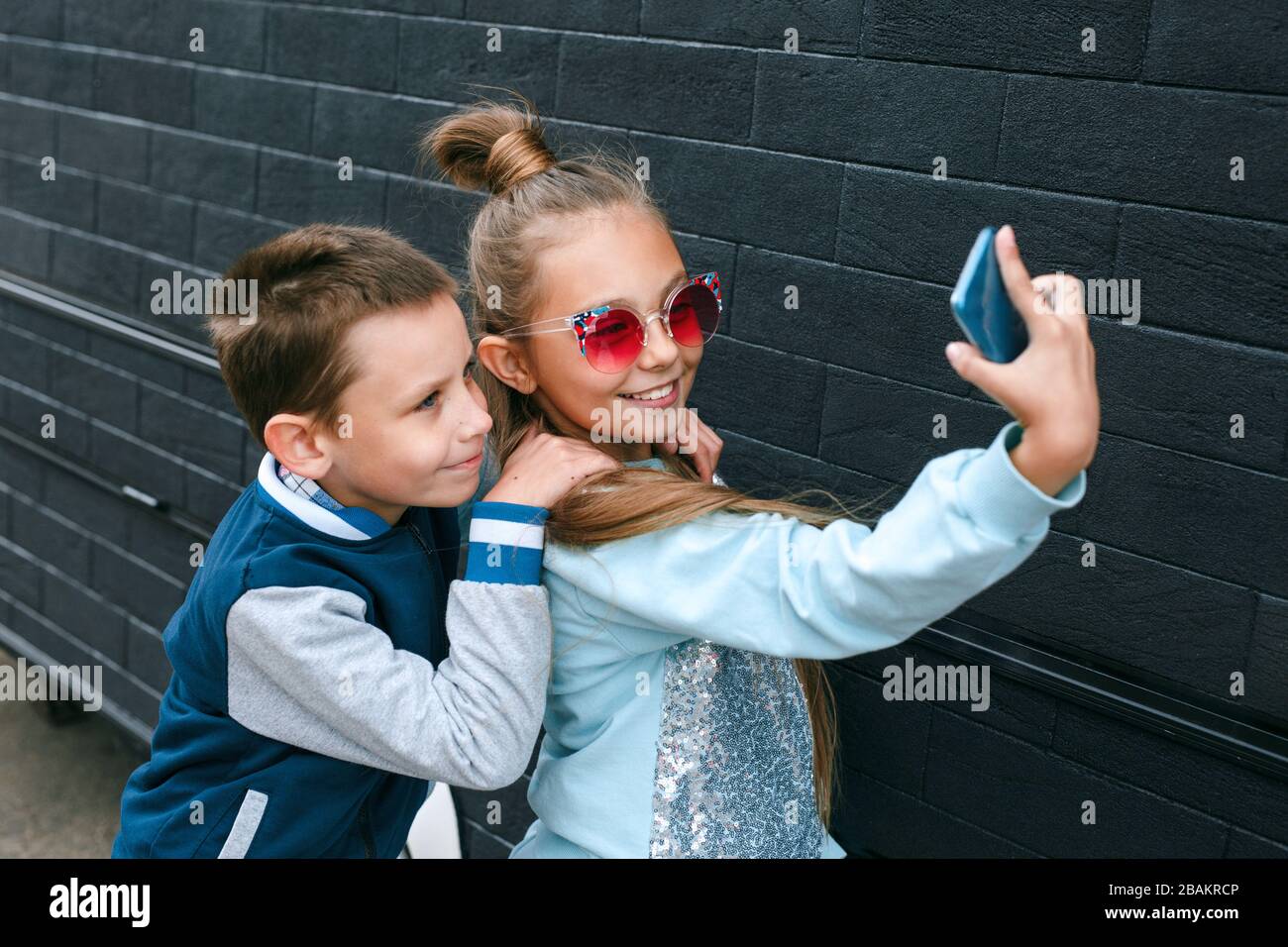 Joli garçon et jolie petite fille dans des lunettes de soleil faisant un  selfie à l'aide d'un smartphone Photo Stock - Alamy