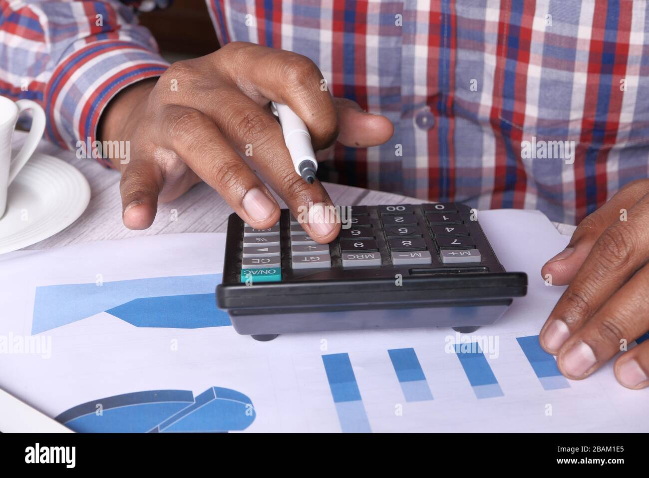 Gros plan sur le jeune homme à l'aide de la calculatrice Banque D'Images