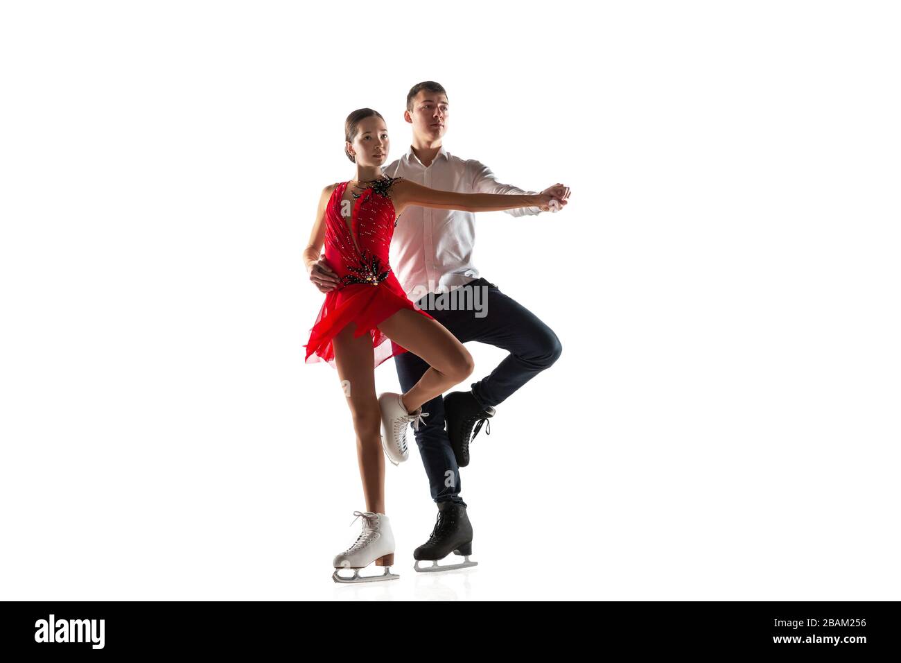 Duo figure patinage isolé sur fond de studio blanc avec copyspace. Deux sportifs pratiquant et formant en action et en mouvement. Plein de grâce et de poids. Concept de mouvement, sport, beauté. Banque D'Images