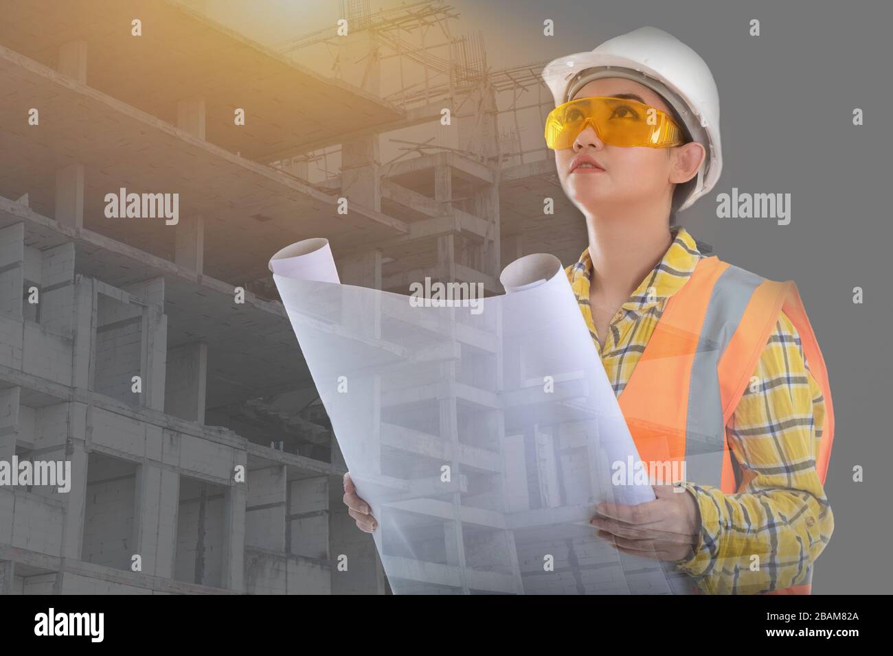 Portrait belle jeune femme Asie ingénieur civil tenant plan dessin en face, planification sur le chantier de construction arrière-plan Banque D'Images
