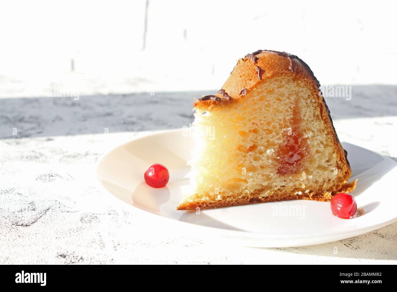 Délicieux gâteau sur la plaque sur la table. Tranches de gâteau sur une plaque. Baies d'une cerise sur un gâteau. Fraise et remplissage crémeux. Fond clair Banque D'Images