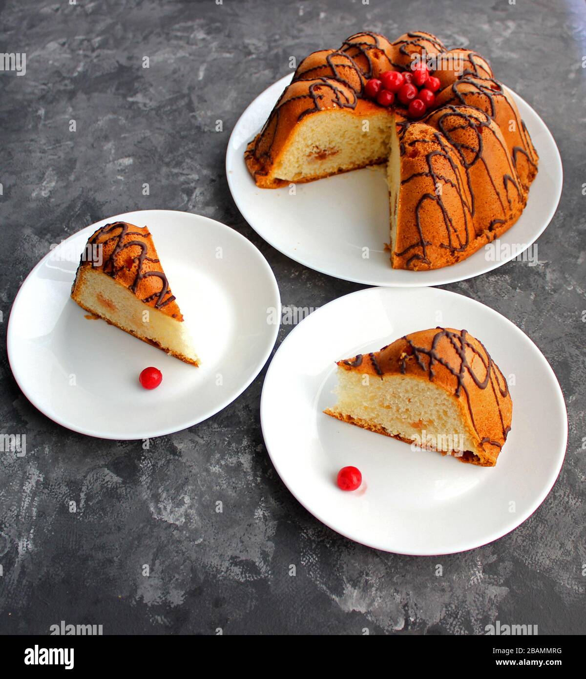 Délicieux gâteau sur la plaque sur la table. Tranches de gâteau sur une plaque. Baies d'une cerise sur un gâteau. Fraise et remplissage crémeux. Fond sombre Banque D'Images